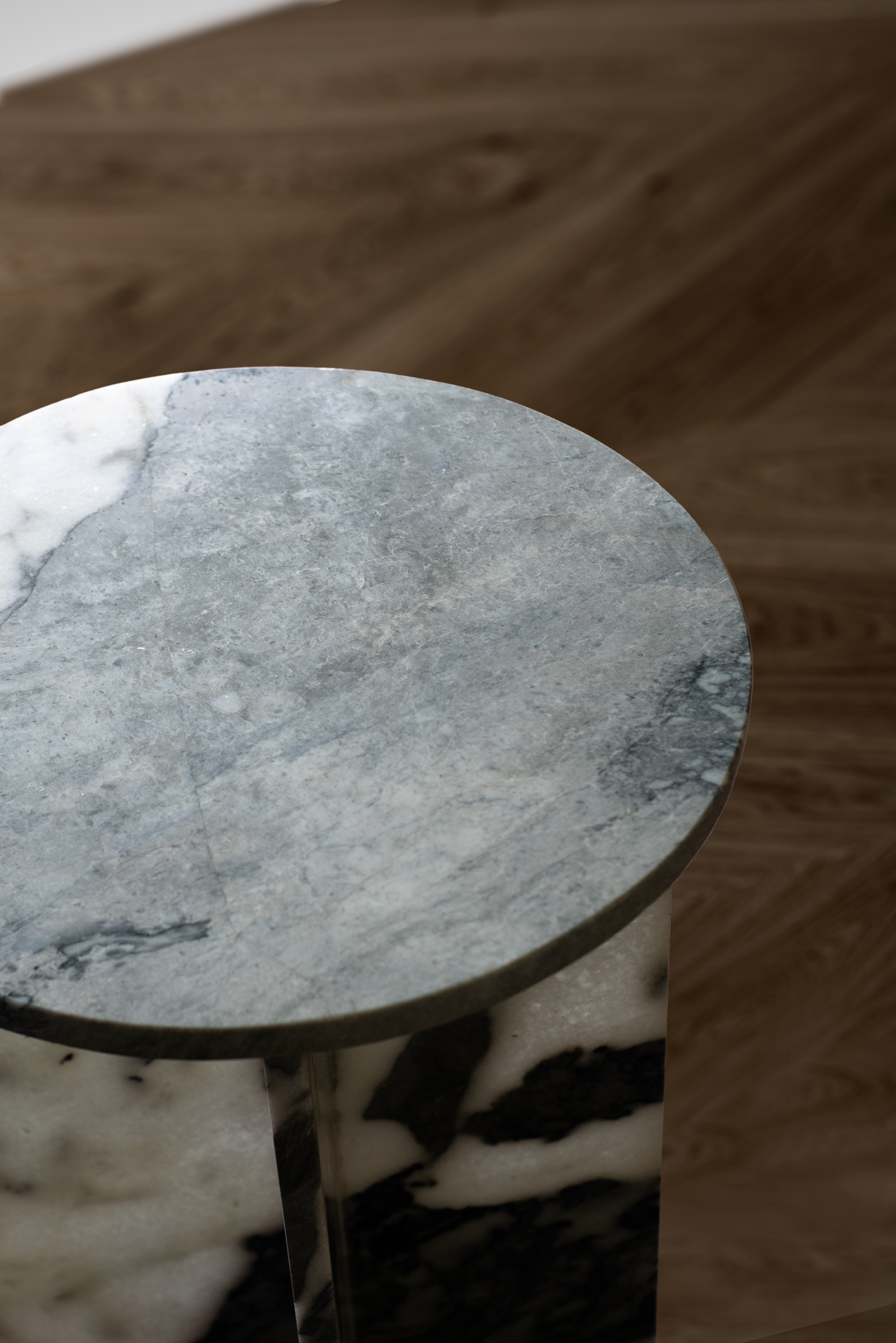 Close-up of the Sibi Accent Table’s polished white marble surface with striking grey patches.