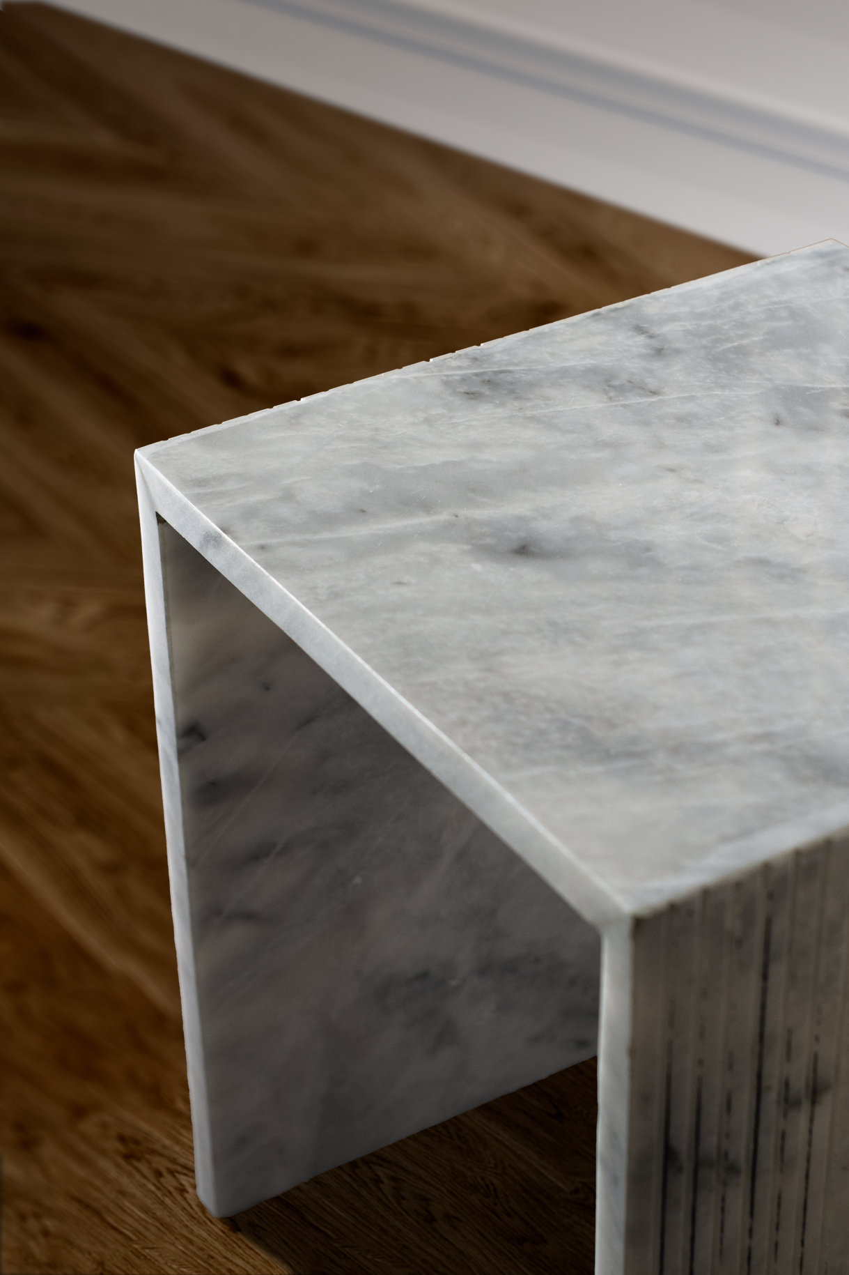 Corrugated white marble side table providing functional style in a chic interior setting.