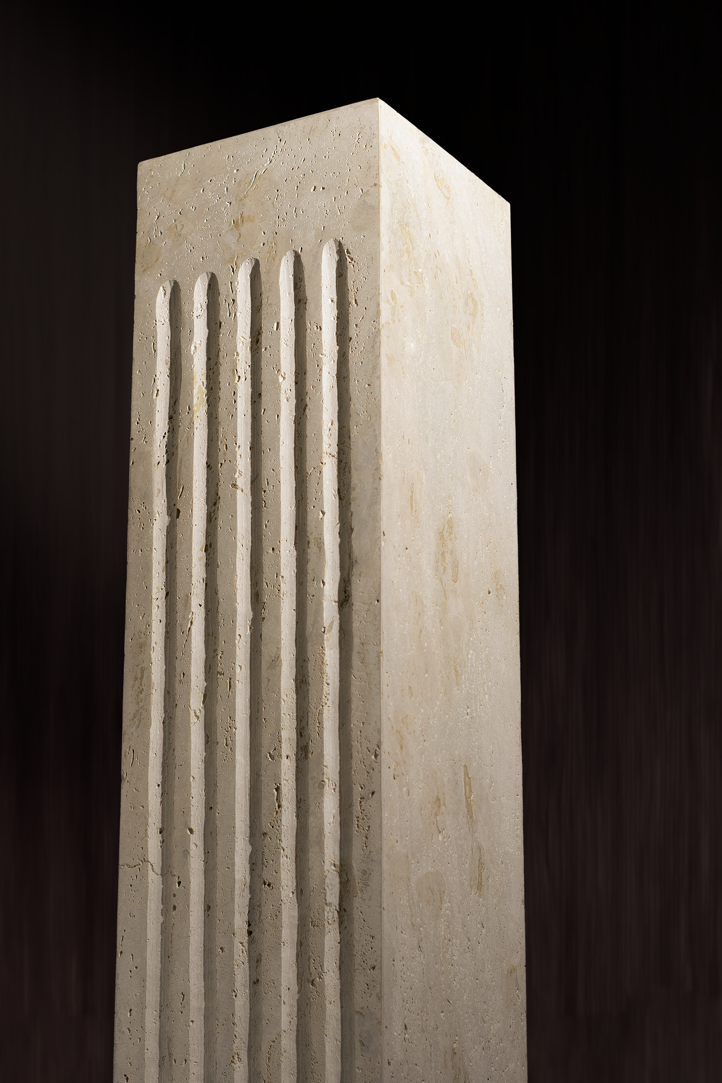 "Titanium Travertine Plinth with a wavy front design showcasing natural stone texture."