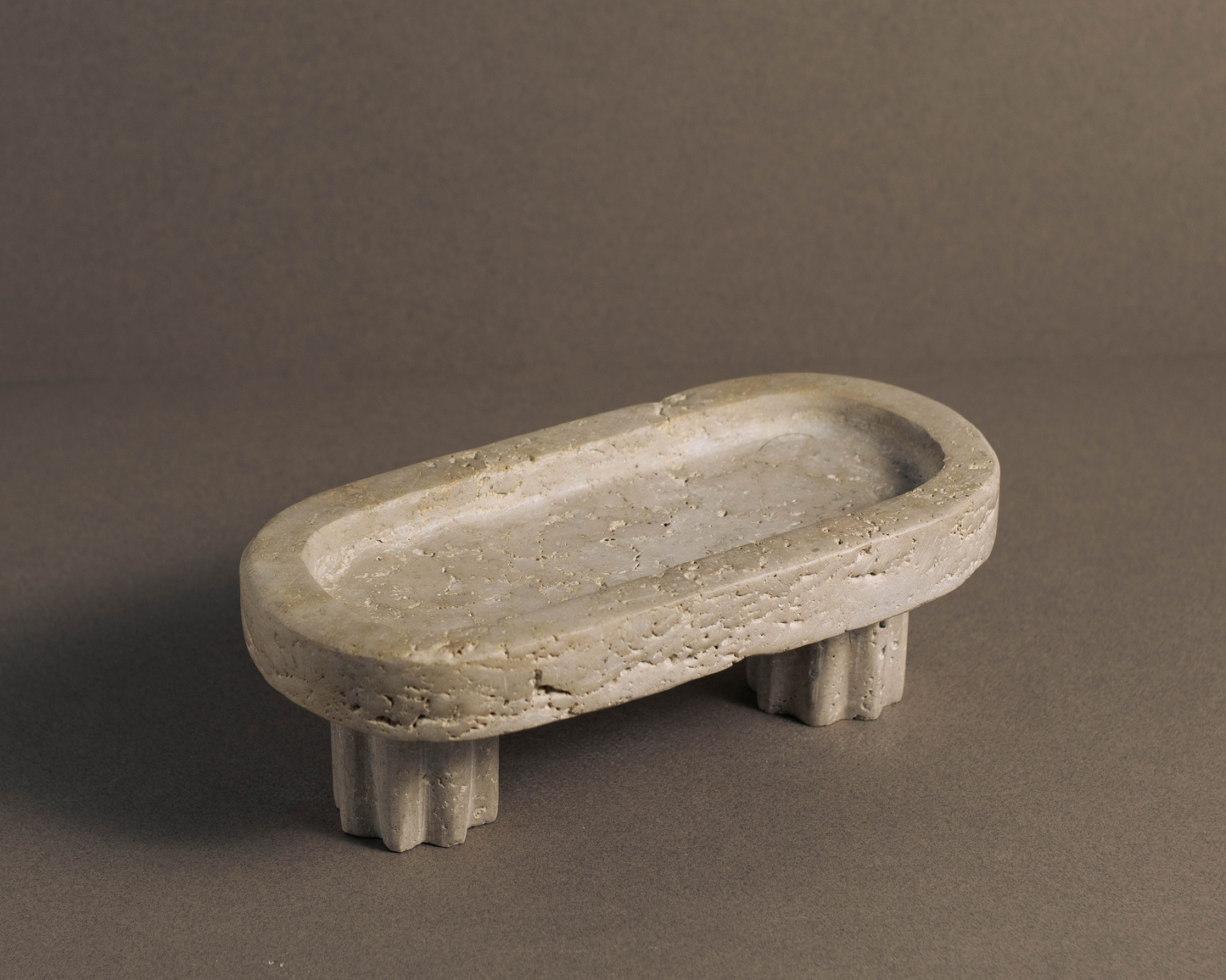 Elegant oval-shaped travertine tray with a column base, showcasing natural stone veining; ideal for home decor, jewelry display, or organizing skincare items.