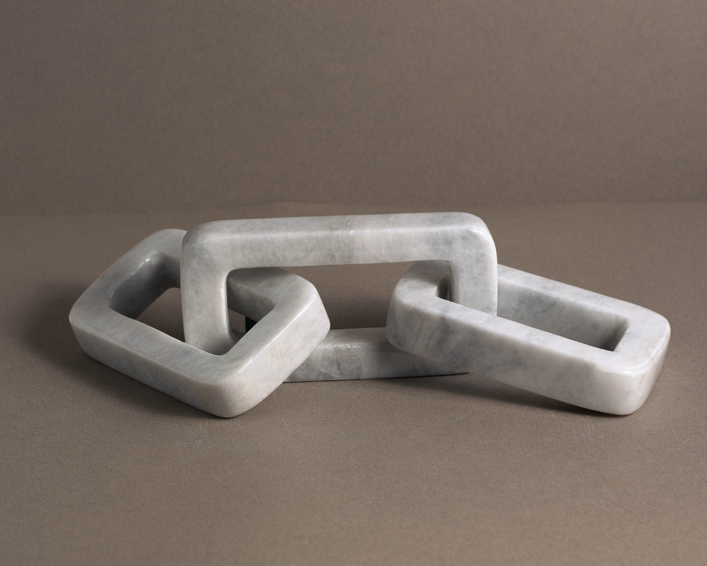 Elegant white marble link sculpture showcasing timeless design and contemporary appeal.
