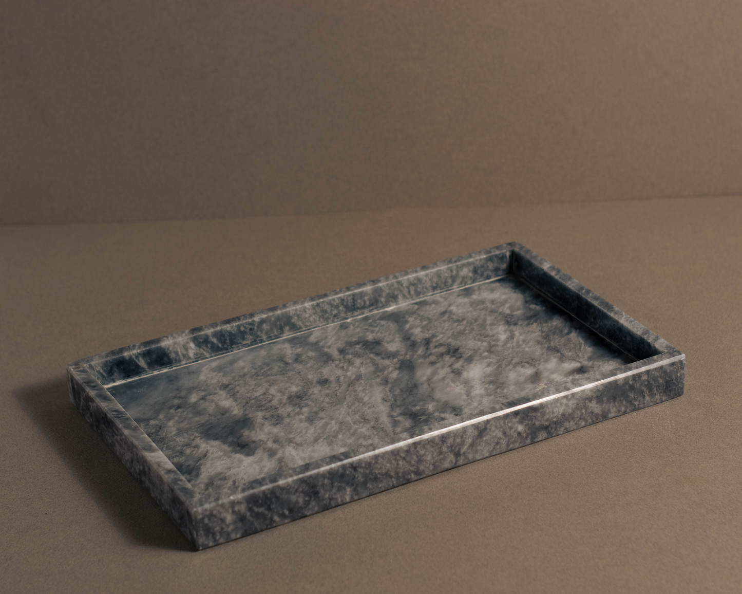 Premium grey marble tray showcasing candles and jewelry in a modern setting.