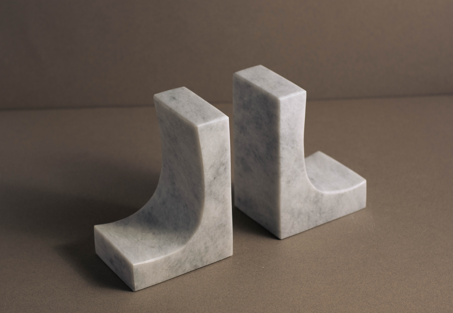 Unique white marble bookends, featuring smooth surfaces and subtle veining for bookshelf styling.