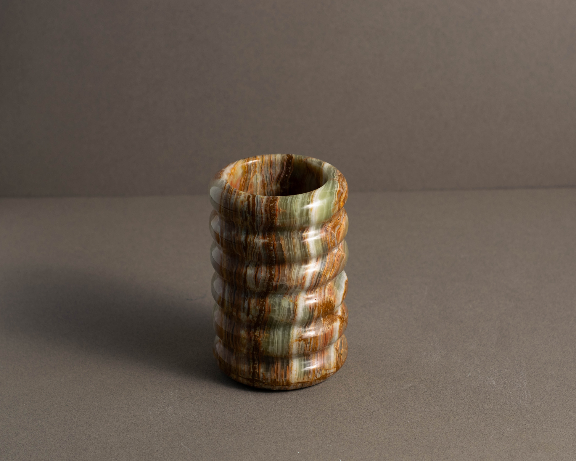 Unique green onyx vase used as a decorative accent on a dining table.