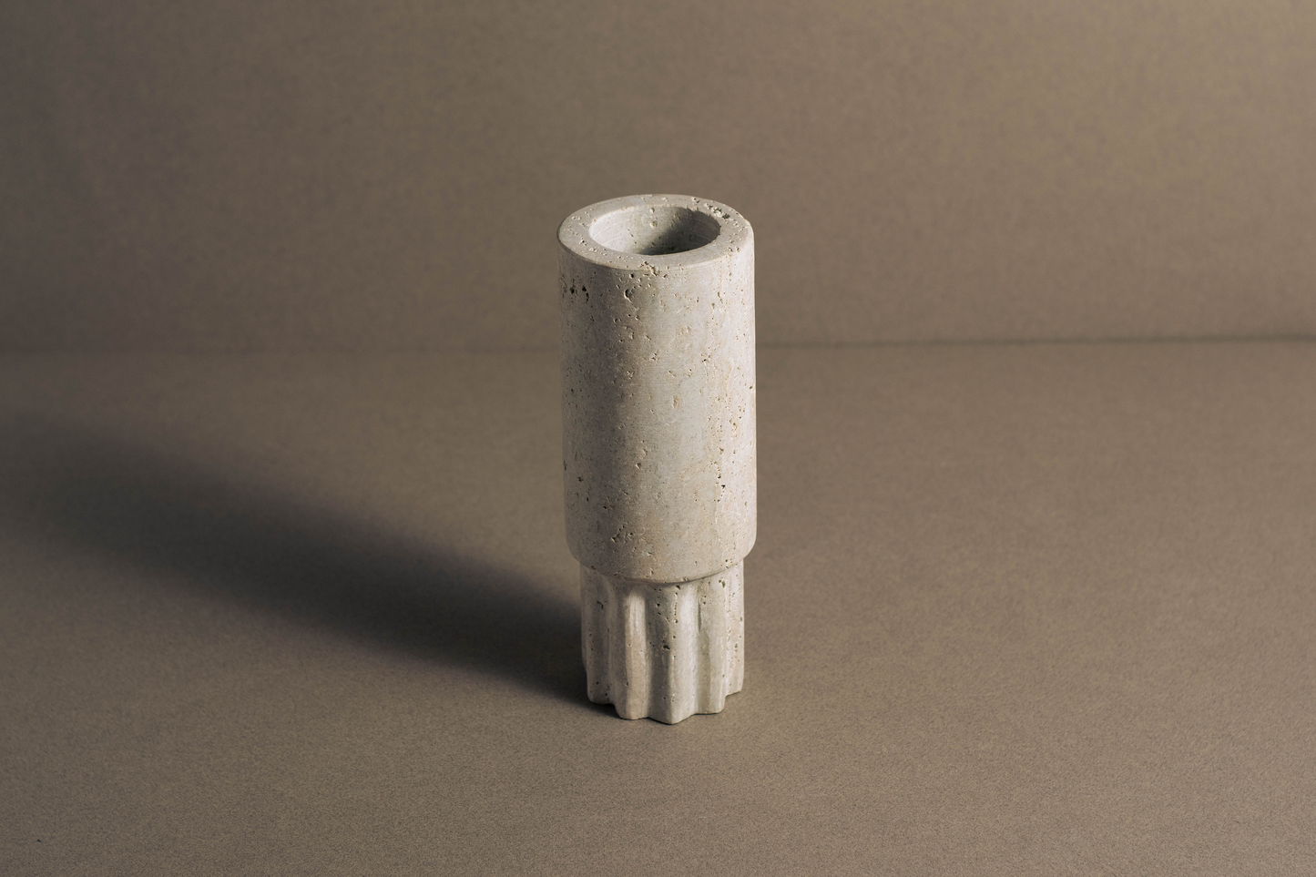 Stylish Travertine Column Vase highlighting unique textures and warm earthy tones.
