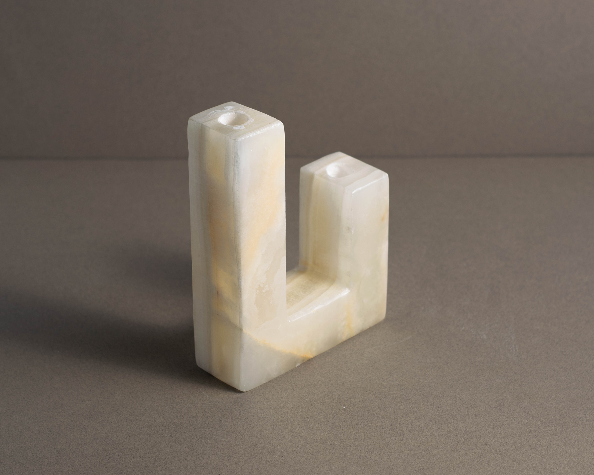 Handcrafted white onyx candle holder with a modern geometric design, perfect for accentuating tabletops or mantels.