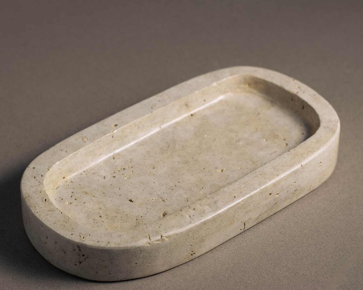 "Oval Travertine Tray showcasing soaps and lotions in a bathroom."