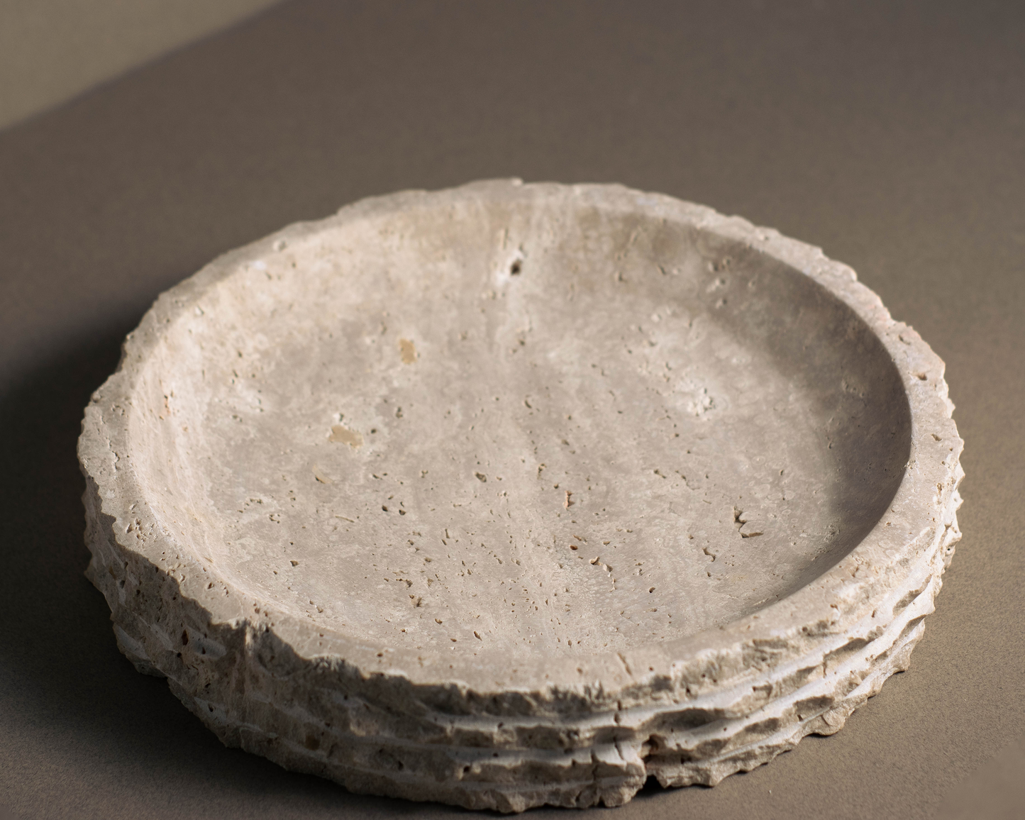 Handcrafted round travertine bowl showcasing unique patterns and warm hues.