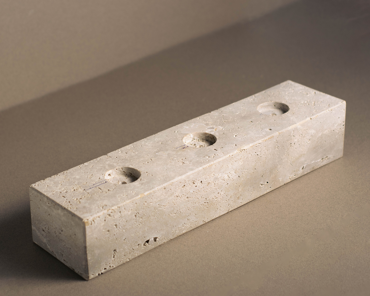 Tealight candle slab in travertine with unique veining, holding tealight candles on a table.