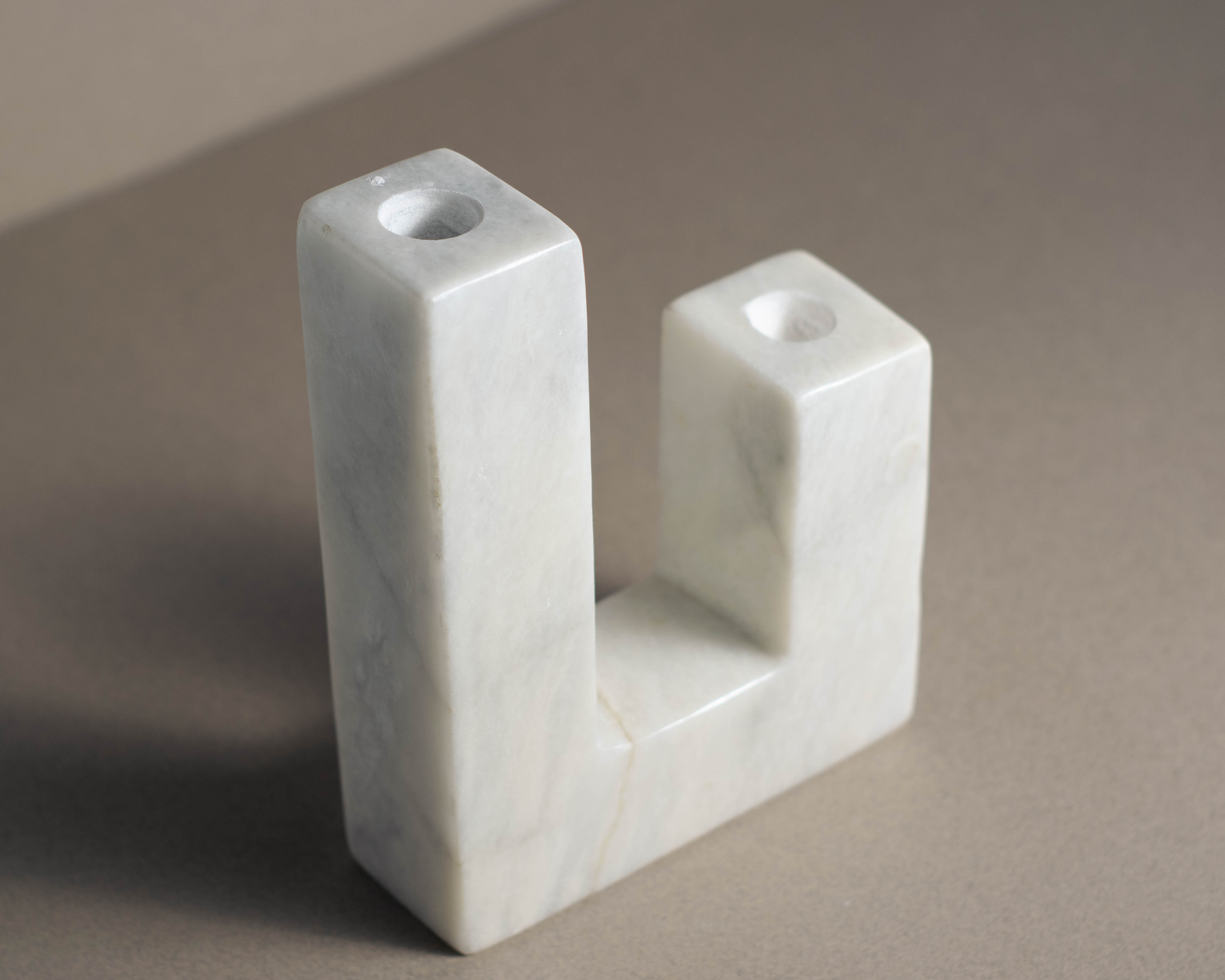 Modern white marble candle holder with minimalist design, adding sophistication to decor.
