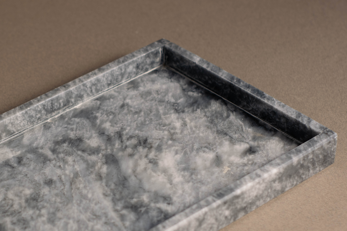 Unique rectangular marble tray with intricate natural veining on a vanity.