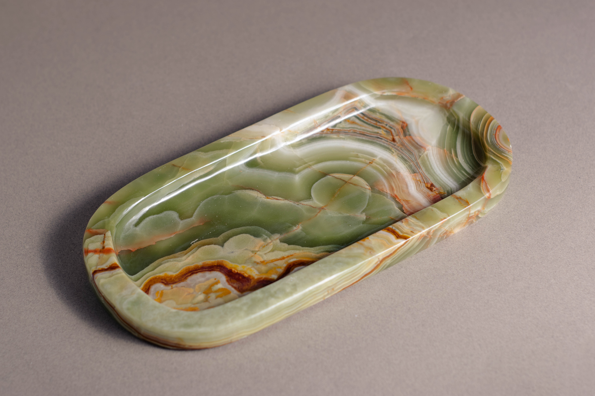 "Aura Tray in Green Onyx with polished surface showcasing vibrant green tones."