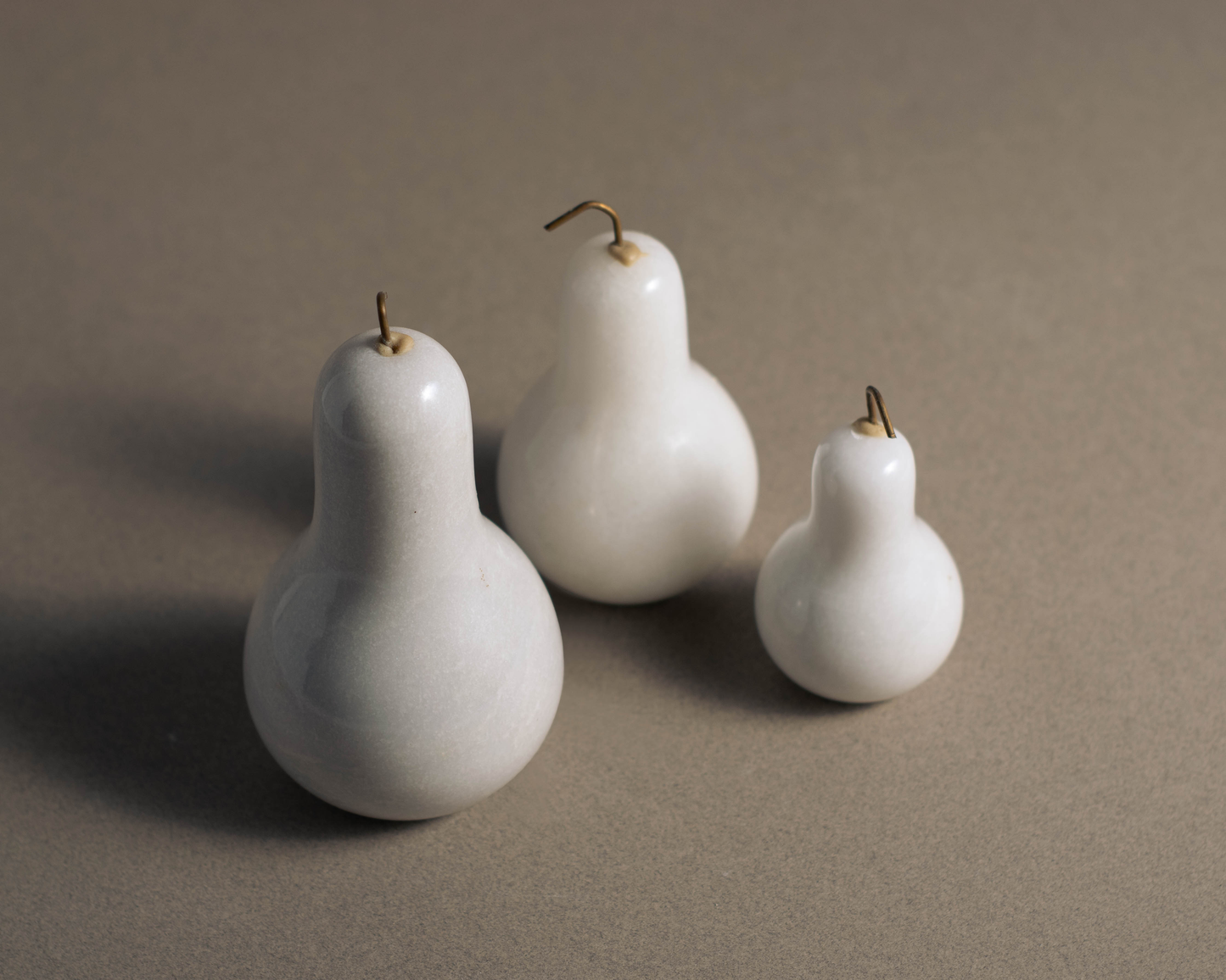 "Elegant Marble Pears Set in White Marble showcasing three intricately sculpted pear-shaped decorative pieces."