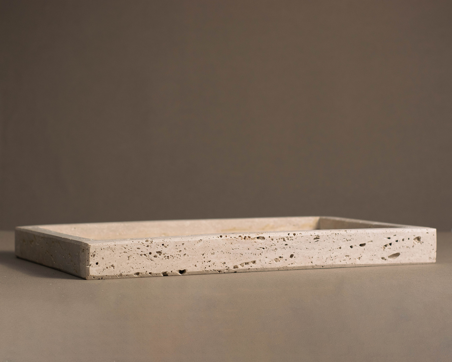 Elegant oblong tray in travertine highlighting its natural beauty and texture.