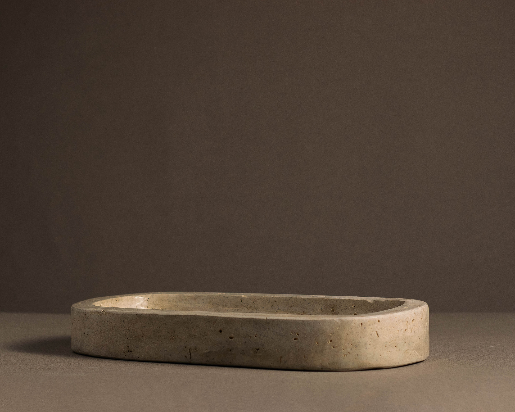 "Elegant Travertine Tray displaying jewelry and candles on a bedroom dresser."