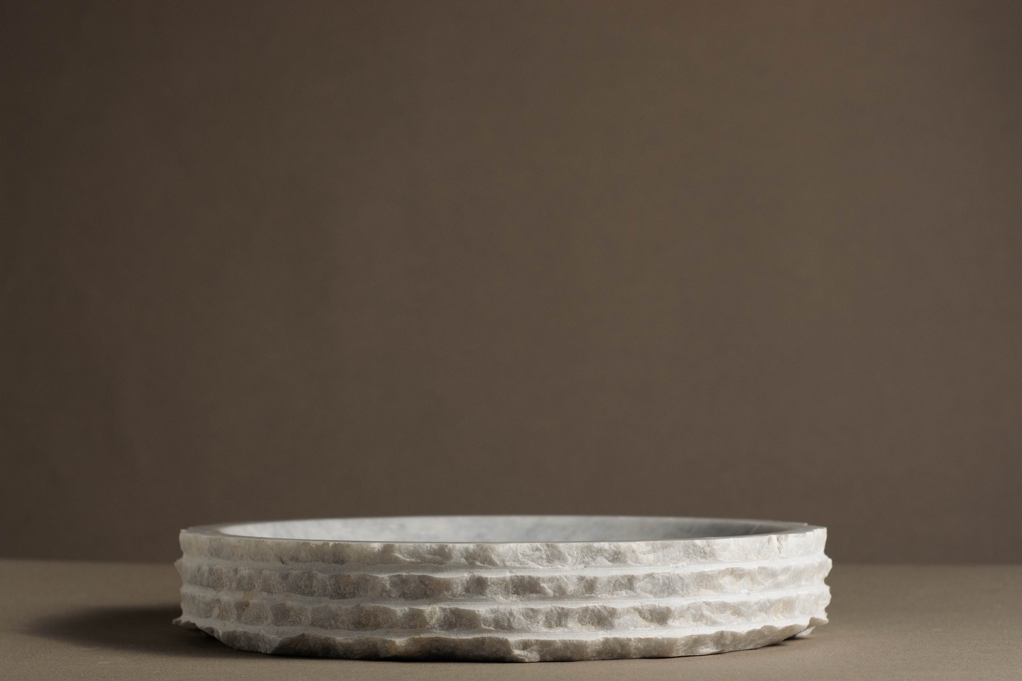 Polished white marble round bowl, adding a touch of sophistication to a modern room.