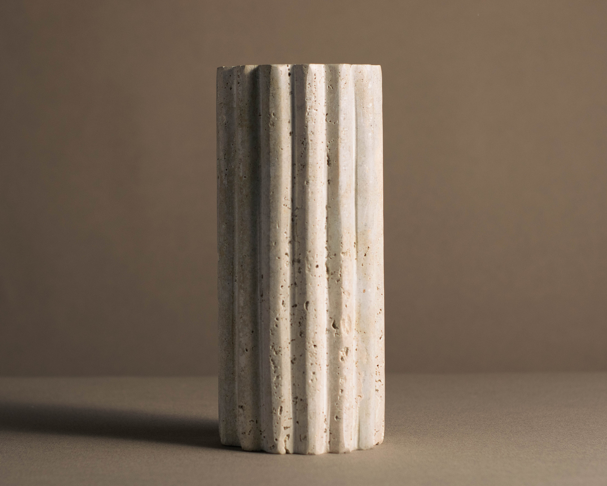 Elegant Hand-Fluted Travertine Vase with distinctive texture and curves, ideal for fresh flowers or as a standalone piece.
