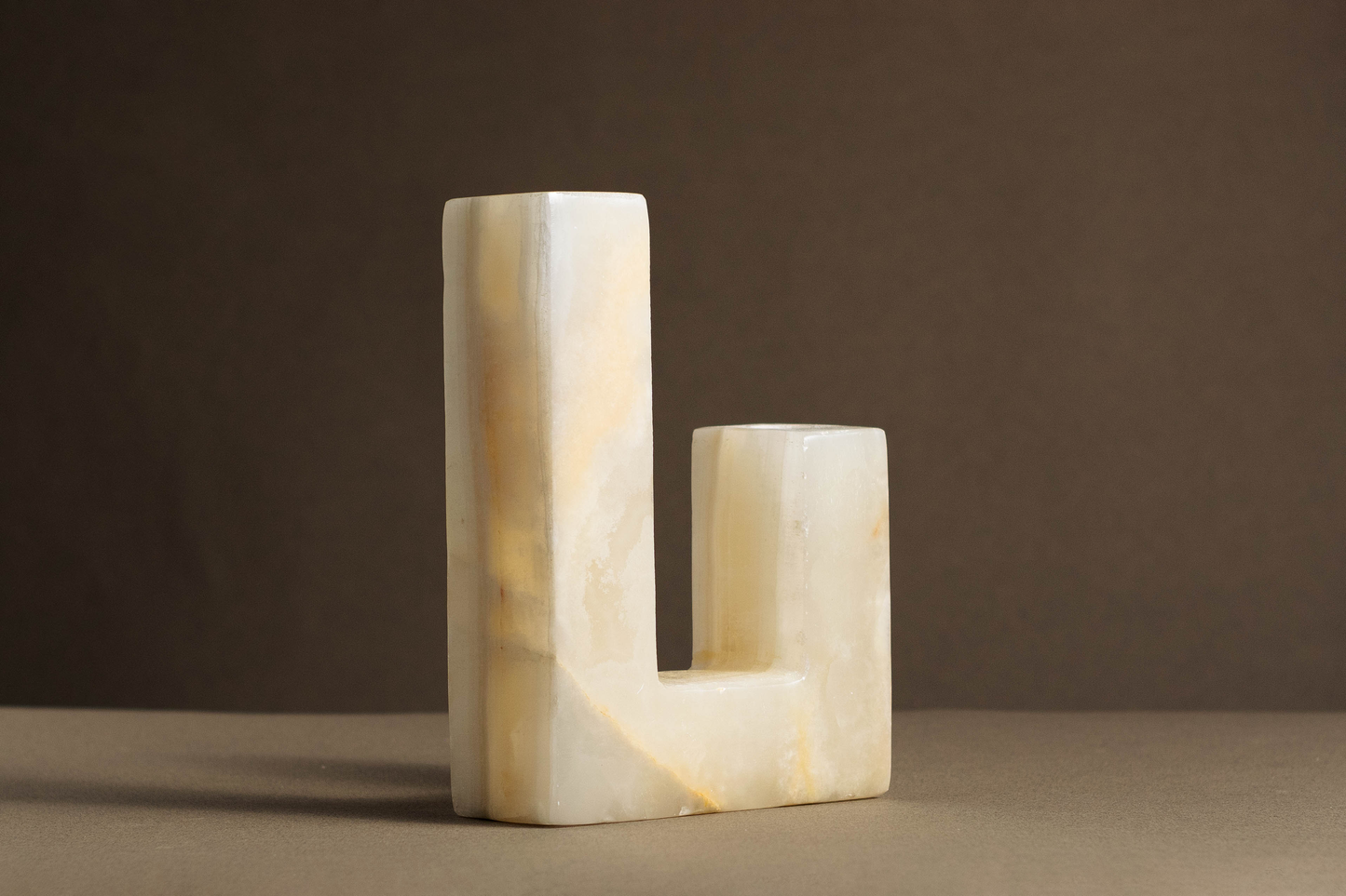 Sophisticated L-shaped candle holder made from high-quality white onyx, featuring a polished finish and unique patterns.