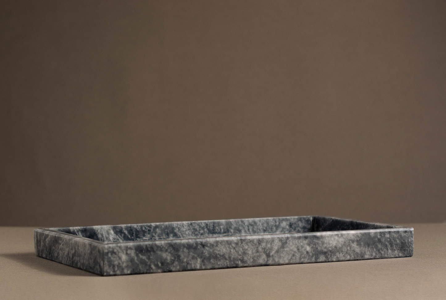 Rectangular marble décor tray with natural grey veining on a white countertop.