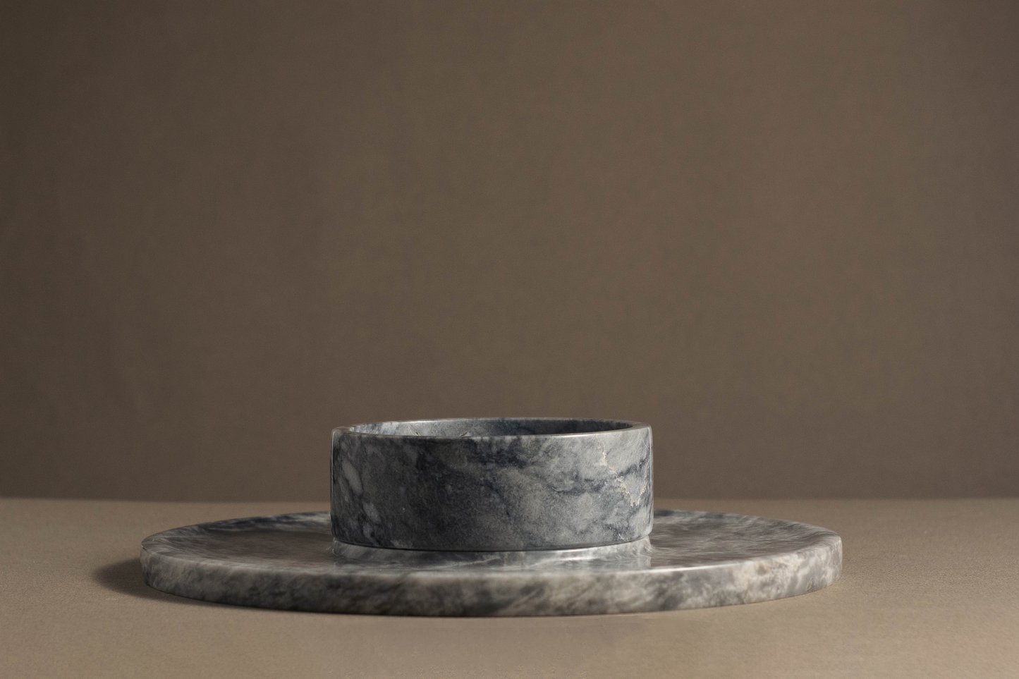 Sophisticated round cheese platter crafted from grey marble, showcasing unique veining and modern design for dining and entertaining.