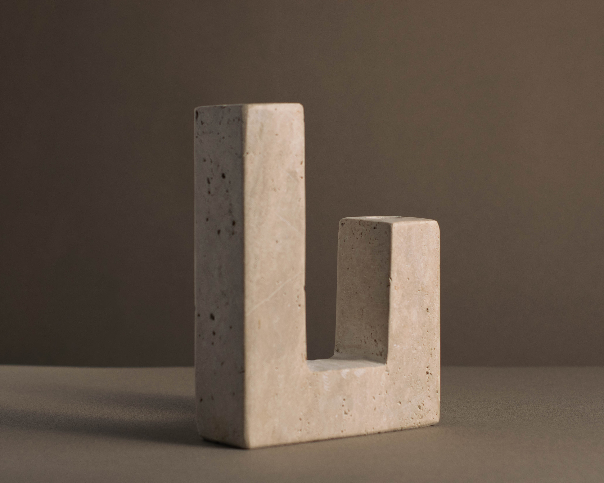 Stylish travertine candle holder with minimalist design, adding sophistication to decor.